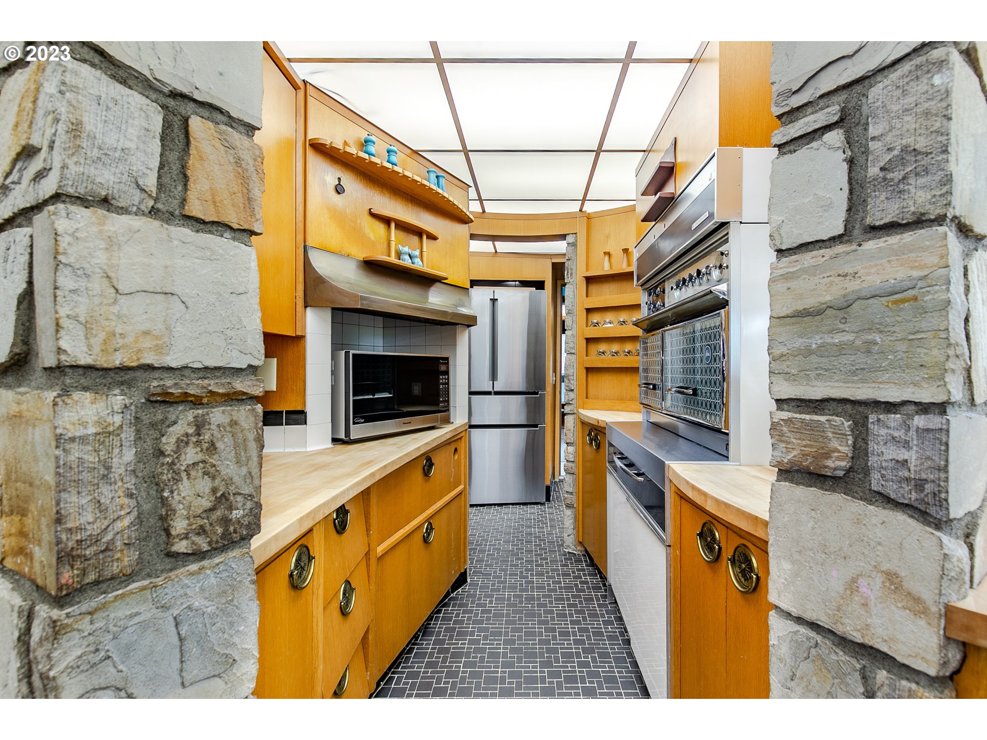 85124 Cloverdale Road Creswell, OR 97426 - Photo 20 of 48 a kitchen with stainless steel appliances kitchen island granite countertop a stove and a microwave