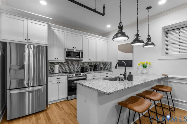 a kitchen with granite countertop a sink stainless steel appliances and chandelier
