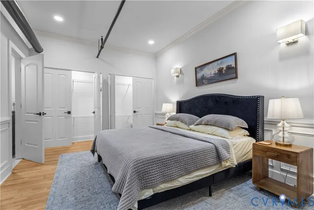 a bedroom with a bed and painting on the wall