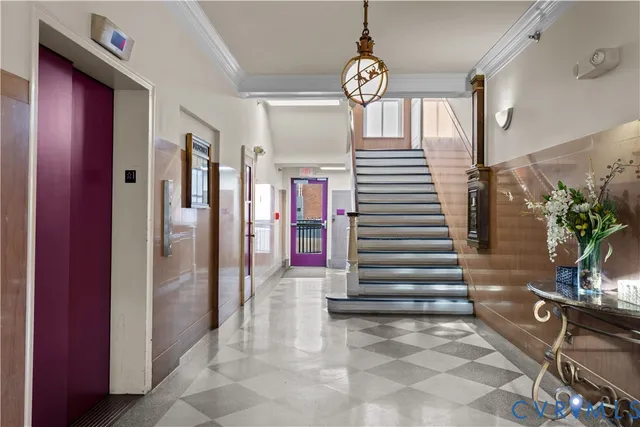 a living room with furniture a chandelier and a rug