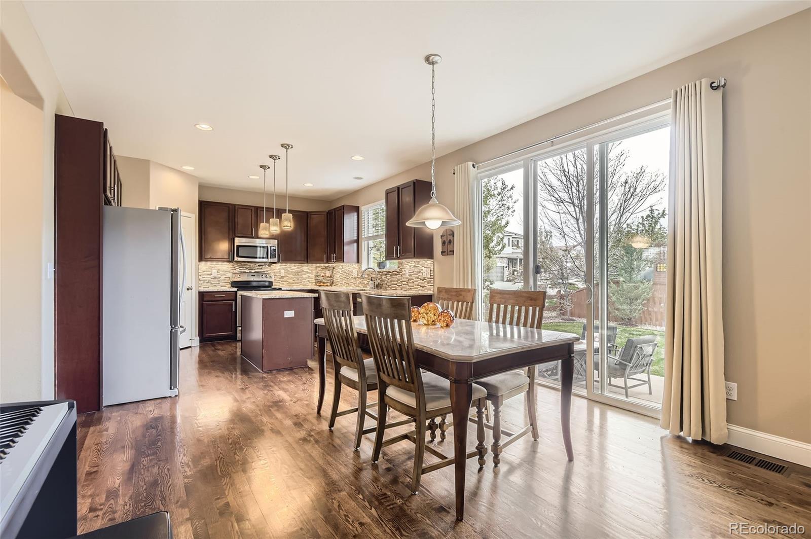 14110 Greenfield Loop Parker, CO 80134 - Photo 13 of 47 a view of a dining room with furniture window and wooden floor