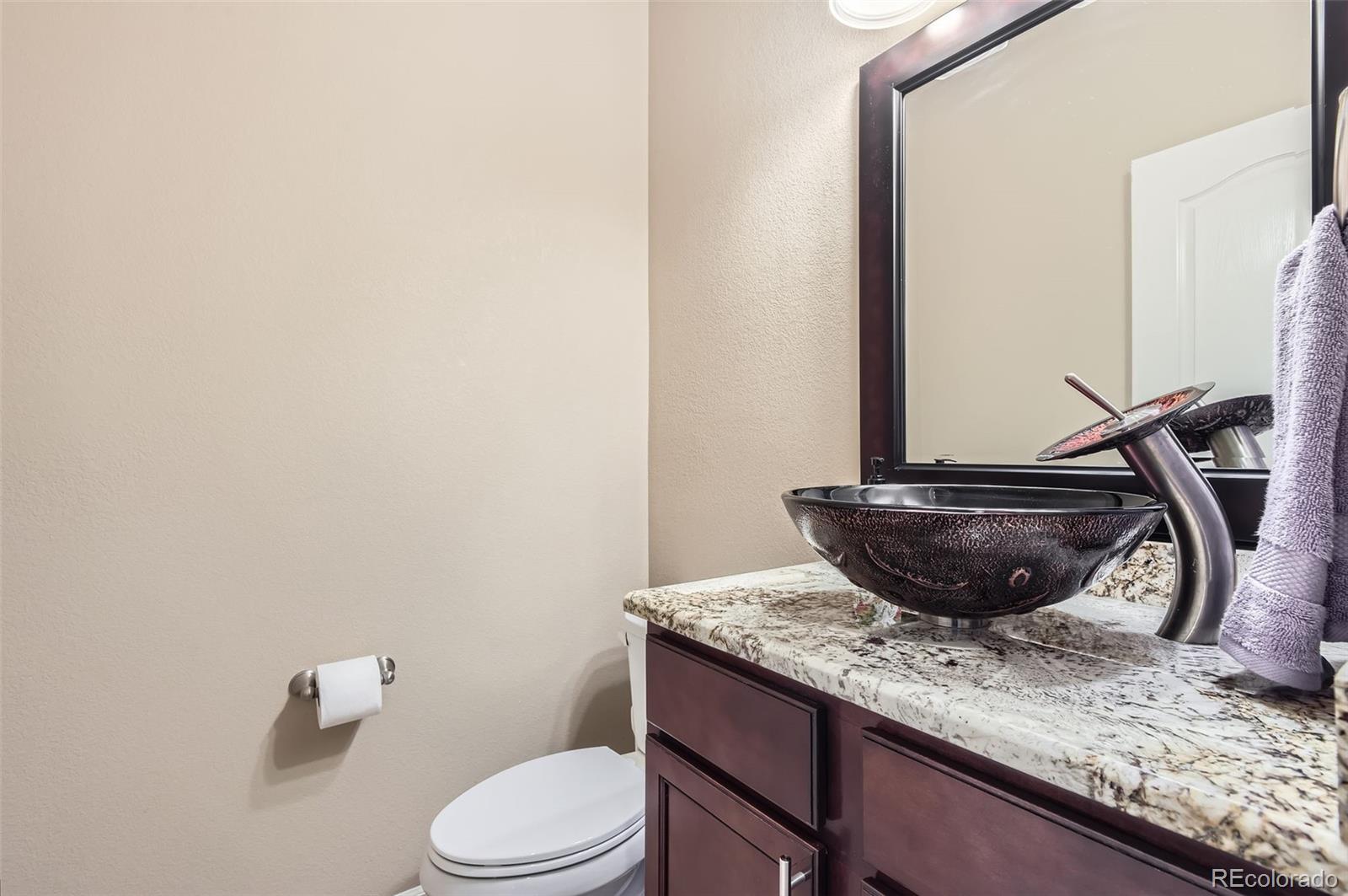 14110 Greenfield Loop Parker, CO 80134 - Photo 17 of 47 a room with a granite countertop toilet and a mirror