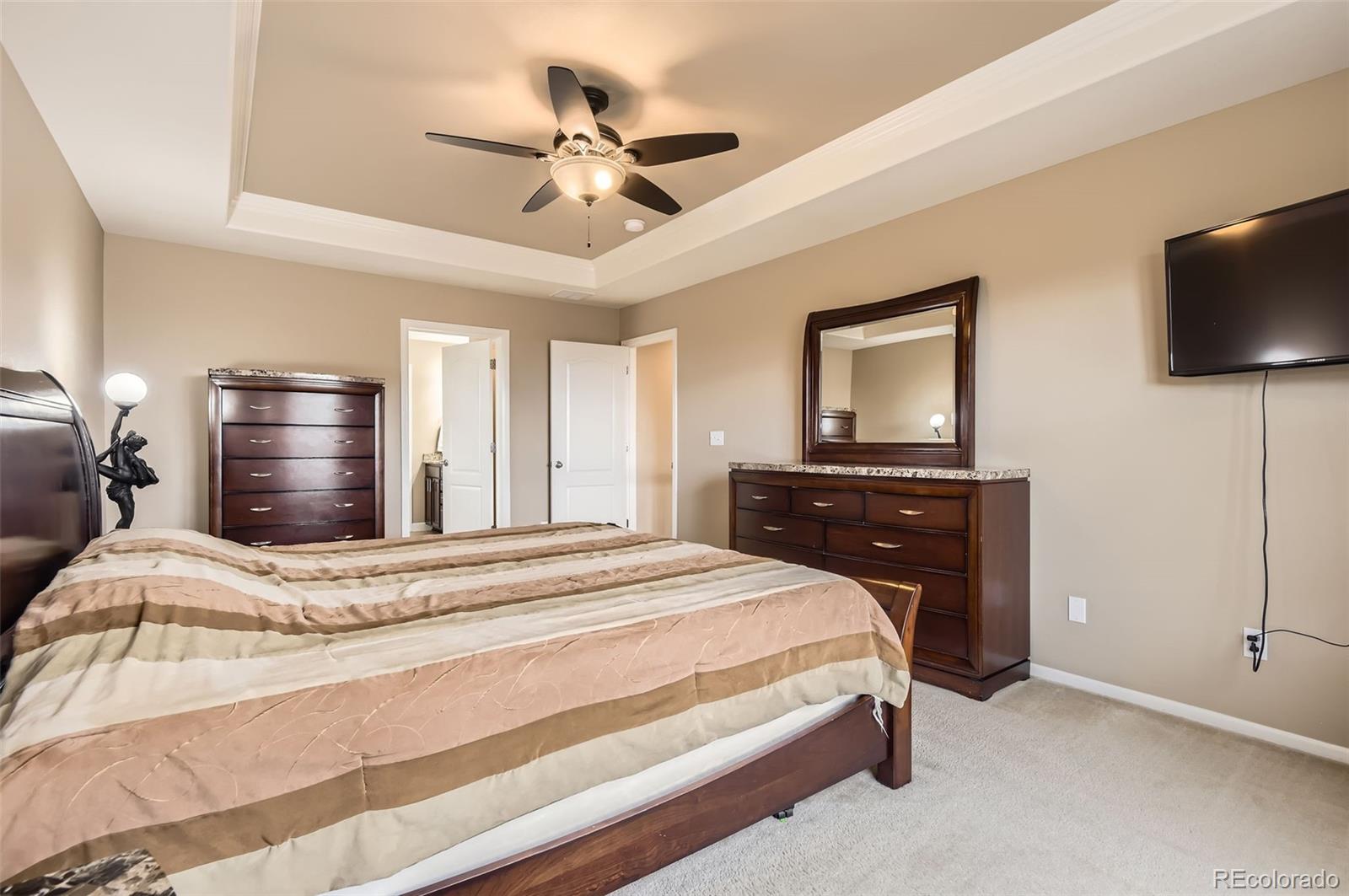 14110 Greenfield Loop Parker, CO 80134 - Photo 19 of 47 a bedroom with a bed and a flat screen tv