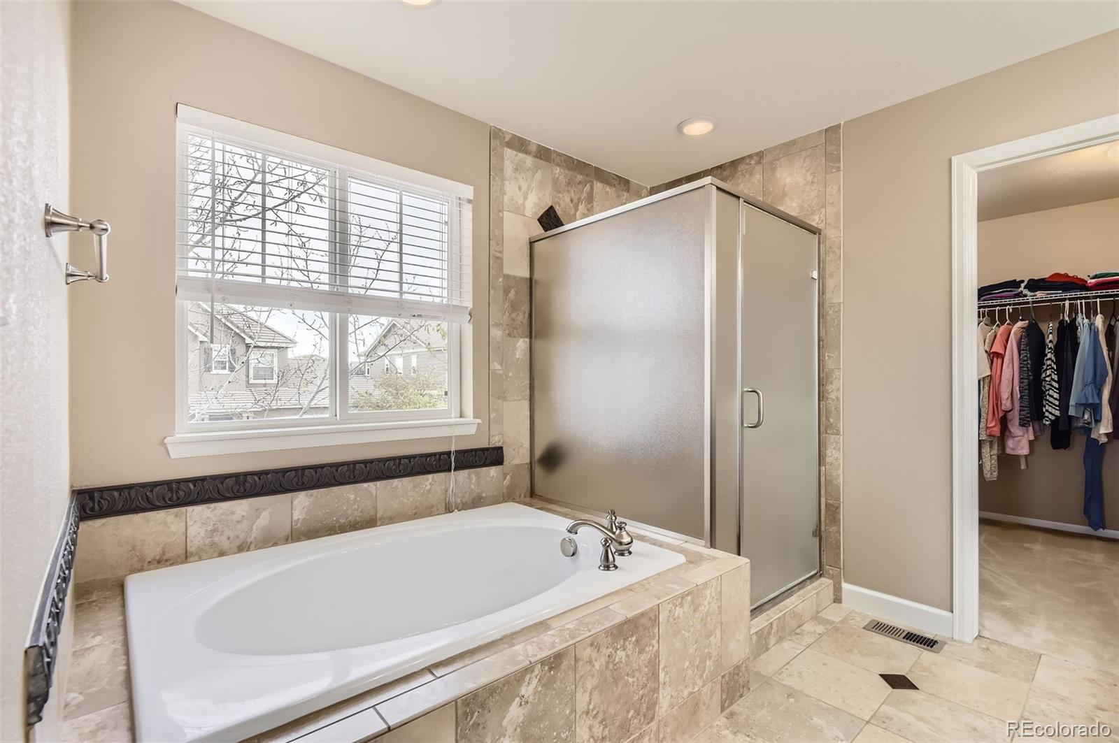 14110 Greenfield Loop Parker, CO 80134 - Photo 21 of 47 a bathroom with a tub a sink and a window