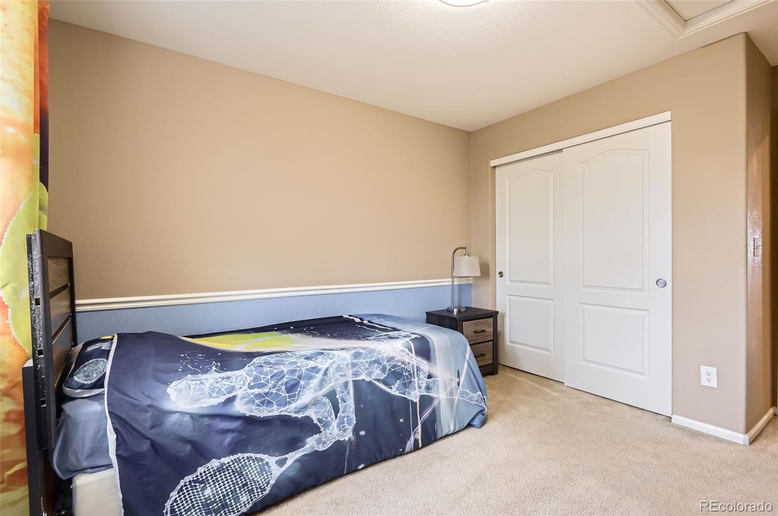 14110 Greenfield Loop Parker, CO 80134 - Photo 24 of 47 a bed sitting in a bedroom next to a window
