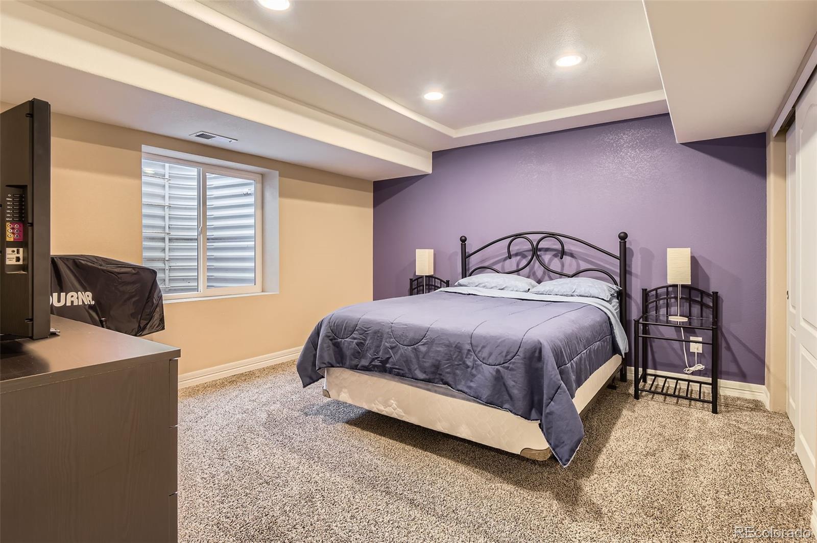 14110 Greenfield Loop Parker, CO 80134 - Photo 31 of 47 a bedroom with a large bed and a flat tv screen on dresser