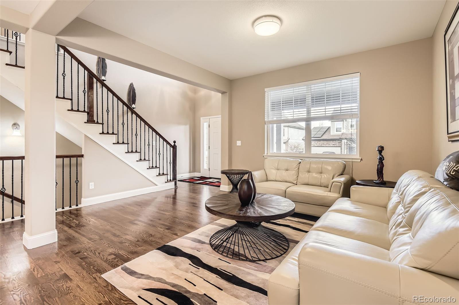 14110 Greenfield Loop Parker, CO 80134 - Photo 7 of 47 a living room with furniture and a dining table with wooden floor