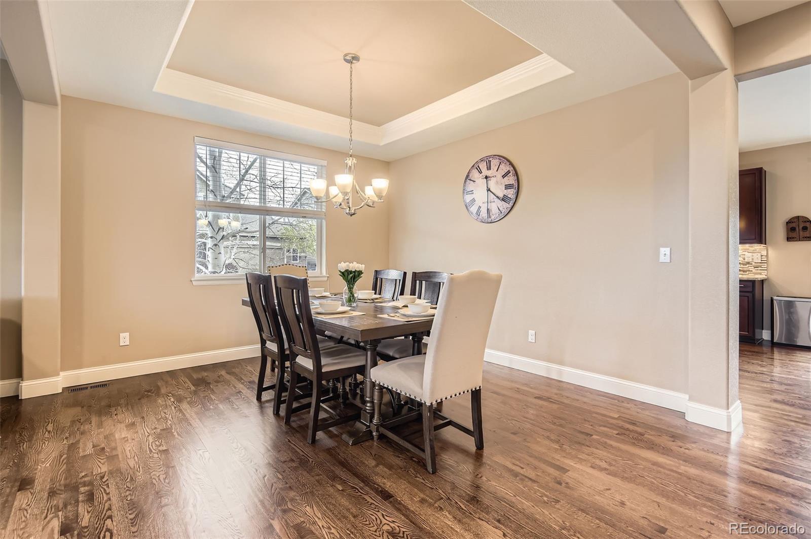 14110 Greenfield Loop Parker, CO 80134 - Photo 8 of 47 a view of a dining room with furniture a chandelier and wooden floor