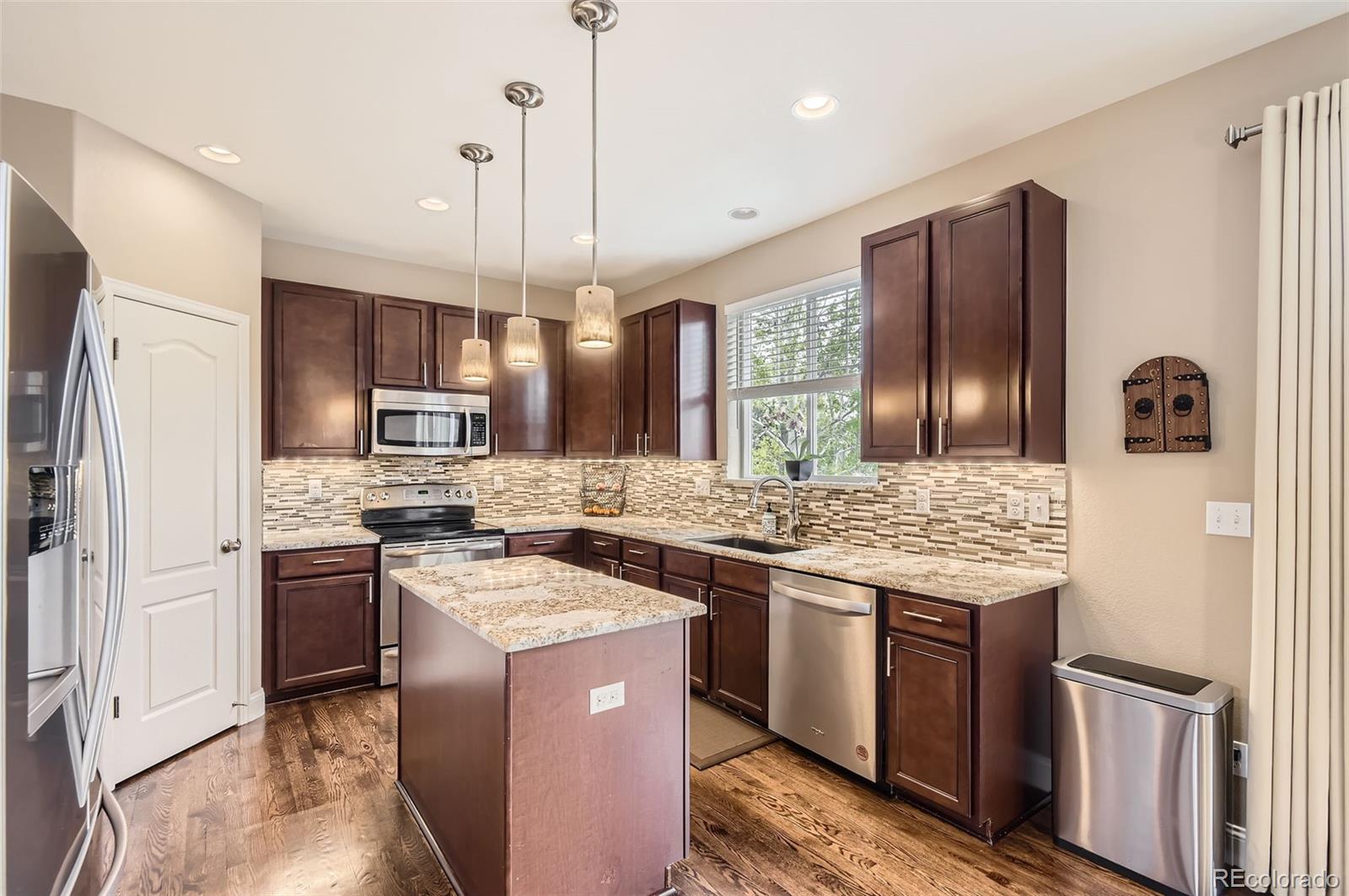 14110 Greenfield Loop Parker, CO 80134 - Photo 10 of 47 a kitchen with stainless steel appliances granite countertop a stove refrigerator sink and refrigerator