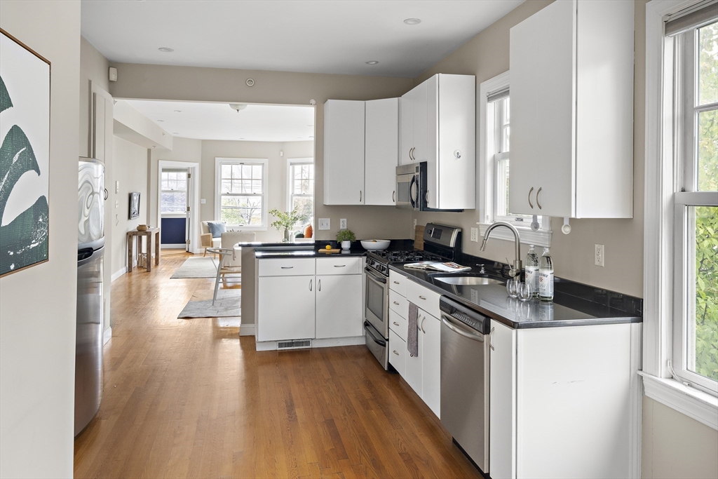 9 Cedar Street, Unit 2 Somerville, MA 02143 - Photo 9 of 20 a kitchen with granite countertop a stove a sink dishwasher and a refrigerator