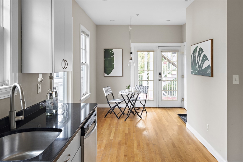 9 Cedar Street, Unit 2 Somerville, MA 02143 - Photo 10 of 20 a dining room with furniture a chandelier and wooden floor