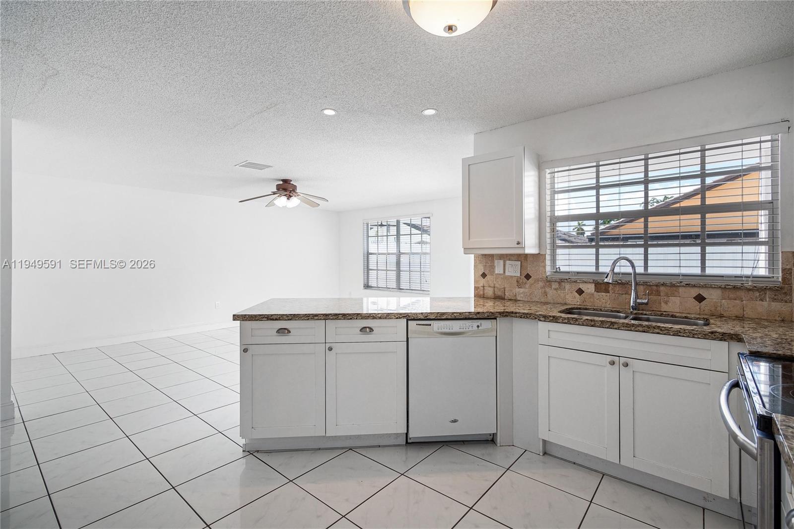 14340 Southwest 90th Street Miami, FL 33186 - Photo 11 of 34 a kitchen with a sink window and cabinets