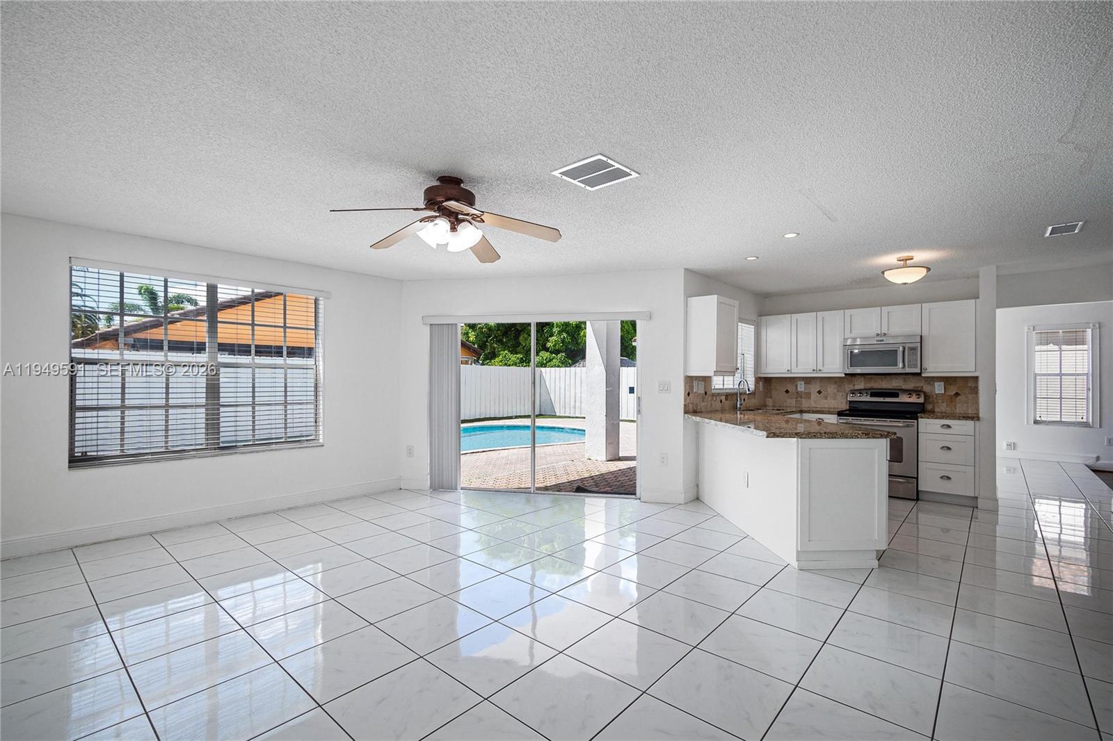 14340 Southwest 90th Street Miami, FL 33186 - Photo 15 of 34 a large white kitchen with a stove a sink dishwasher and a refrigerator