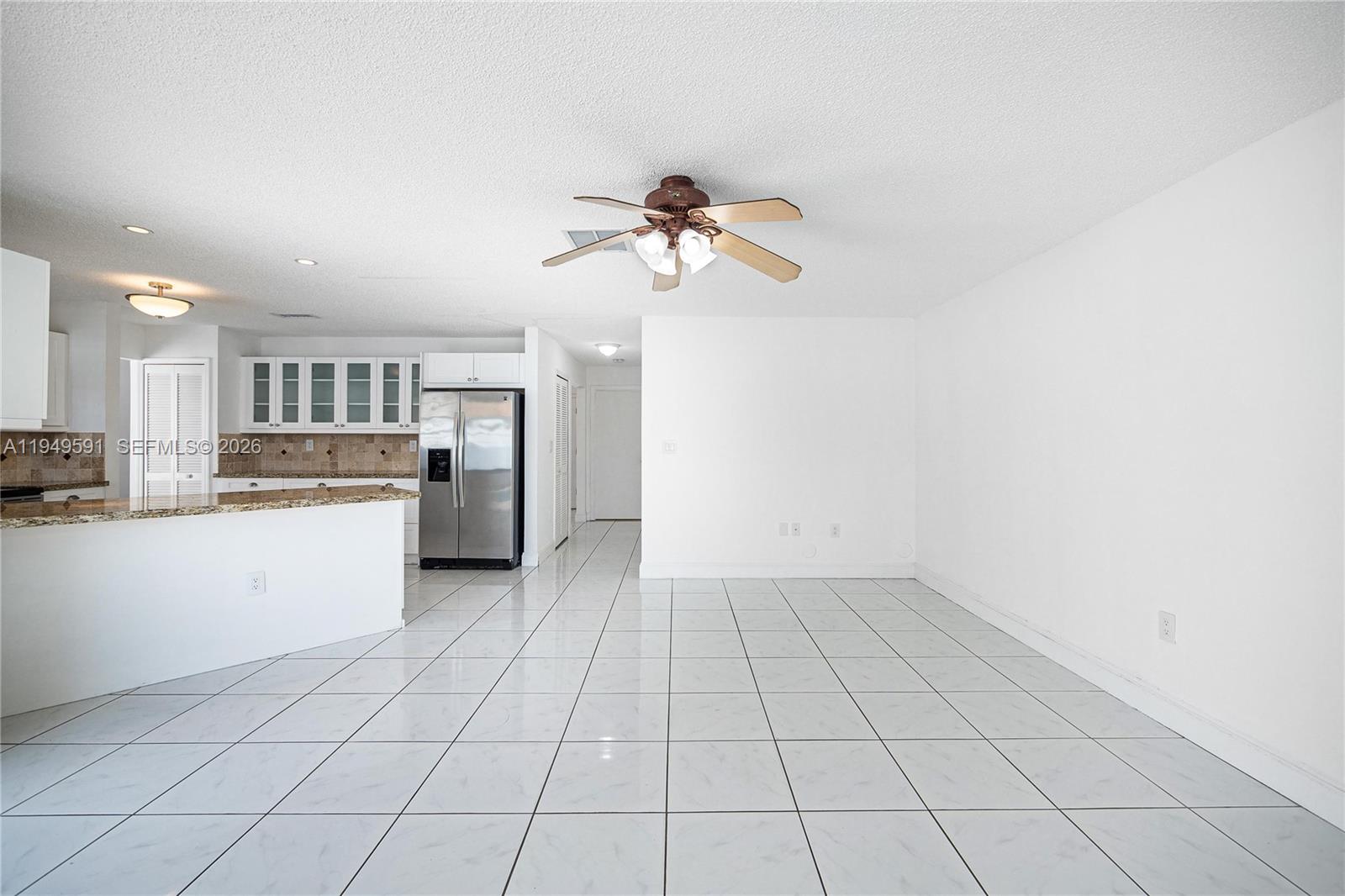 14340 Southwest 90th Street Miami, FL 33186 - Photo 20 of 34 a view of a kitchen with wooden cabinet and a refrigerator