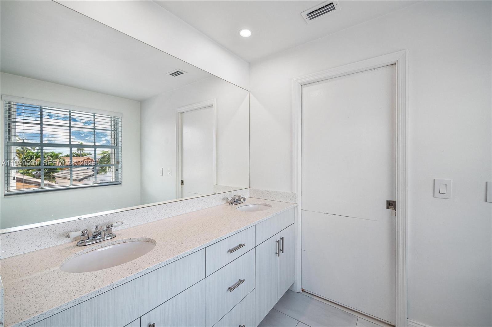 14340 Southwest 90th Street Miami, FL 33186 - Photo 28 of 34 a spacious bathroom with a double vanity sink and a mirror