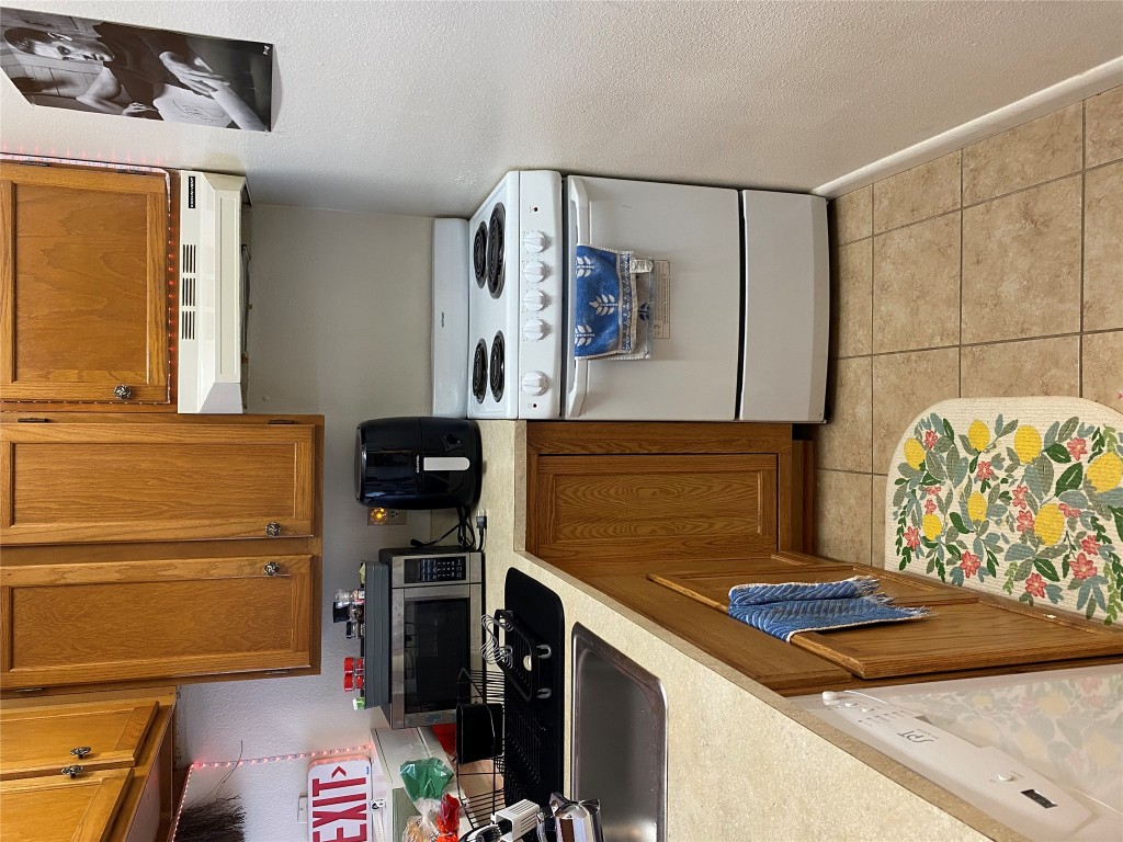1905 San Gabriel Street, Unit 103 Austin, TX 78705 - Photo 16 of 21 a kitchen with a stove a microwave and cabinets