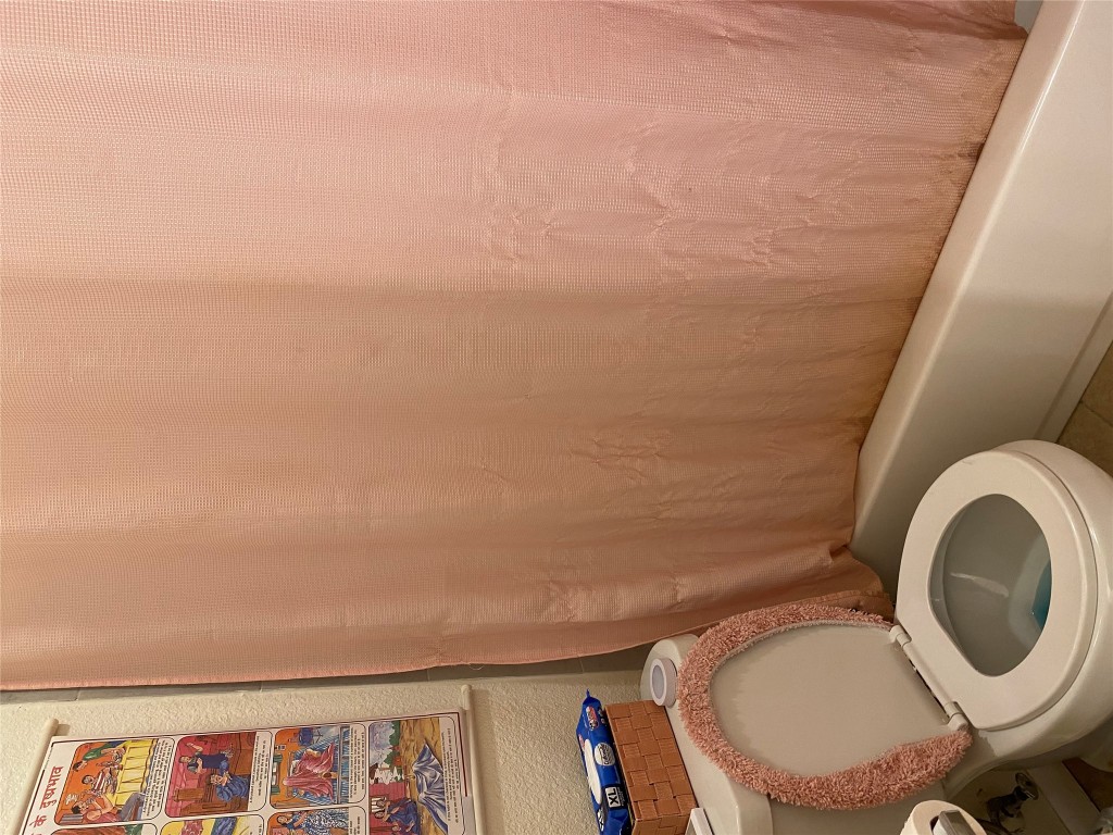 1905 San Gabriel Street, Unit 103 Austin, TX 78705 - Photo 18 of 21 a white toilet sitting next to a shower curtain