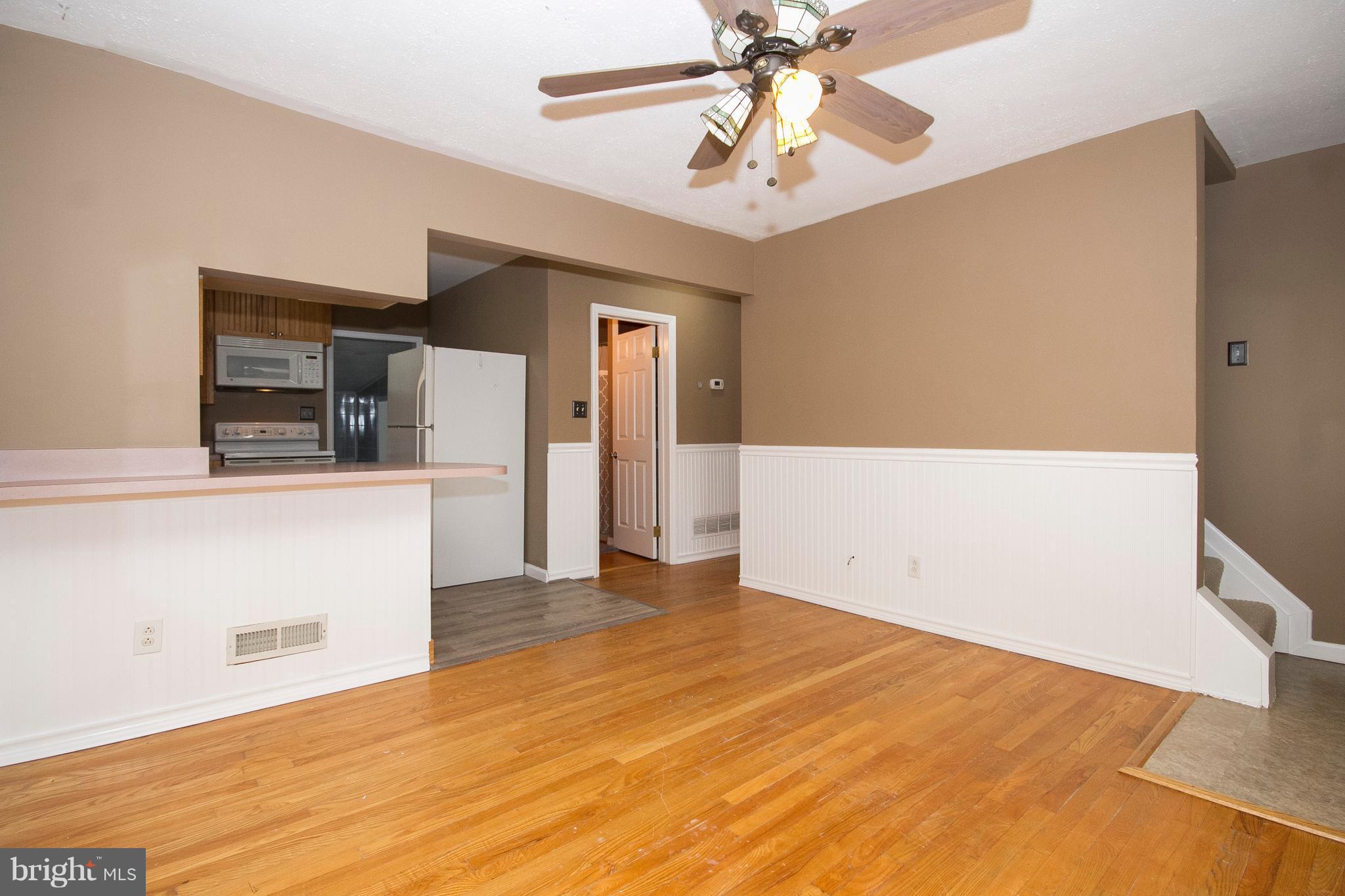 1713 Brookview Road Dundalk, MD 21222 - Photo 4 of 21 a view of a livingroom with wooden floor and a ceiling fan