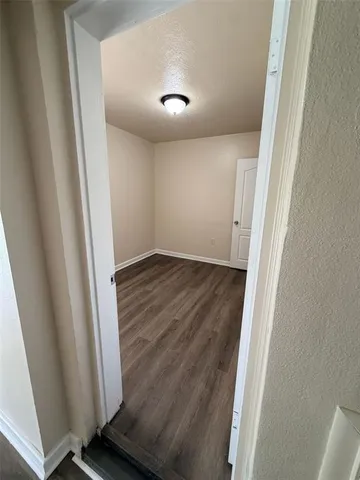 an empty room with wooden floor and fireplace