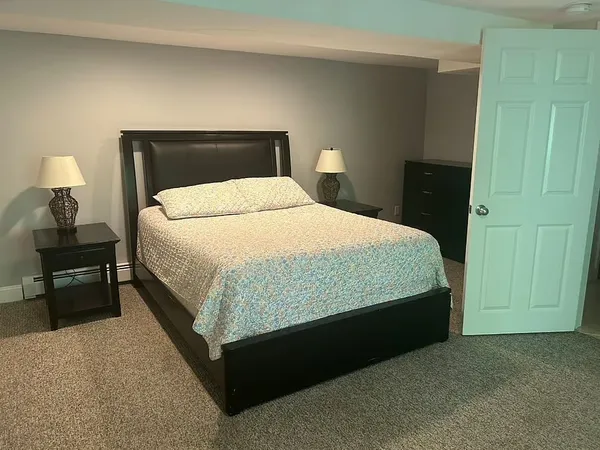 a spacious bedroom with a bed and lamp with window