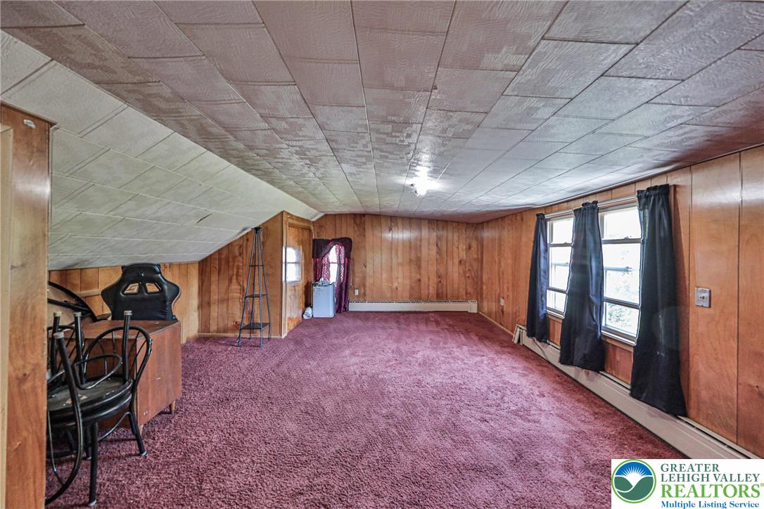 417 3rd Street Lehighton, PA 18235 - Photo 25 of 39 This versatile attic space boasts wood paneling and two windows, offering potential for various uses.
