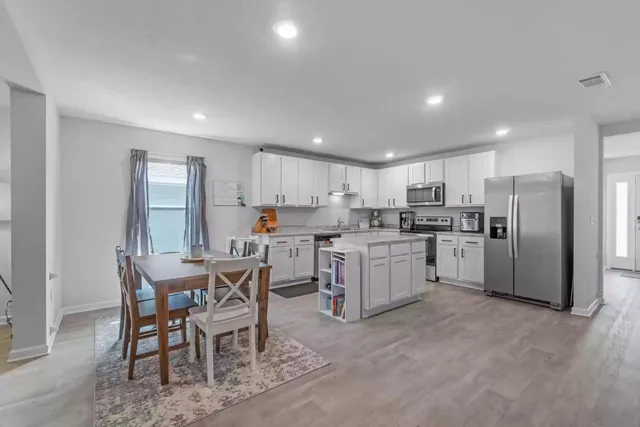 a kitchen with white cabinets and stainless steel appliances