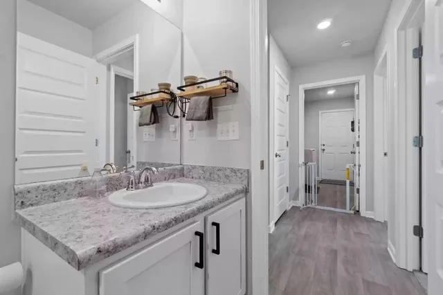 a bathroom with a granite countertop sink a mirror and shower