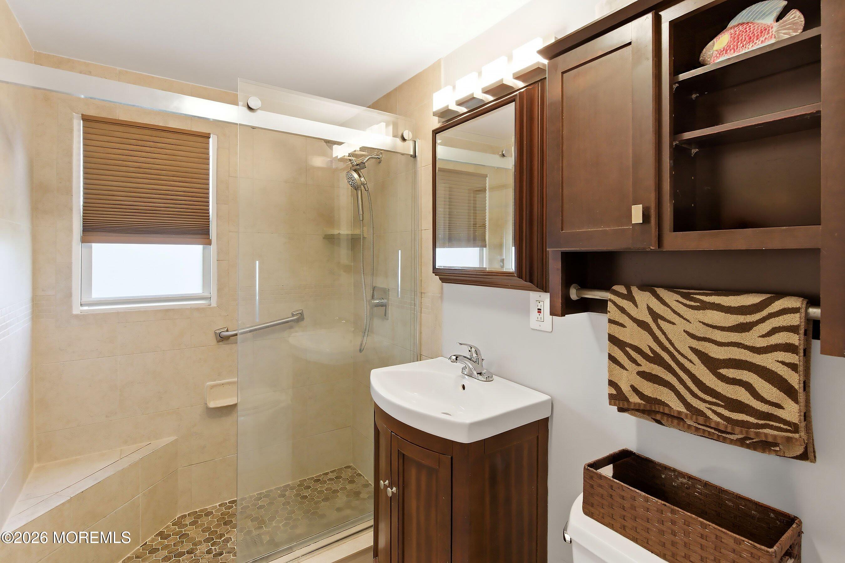 412 Moore Road Neptune Township, NJ 07753 - Photo 19 of 36 a bathroom with a sink a mirror and a shower