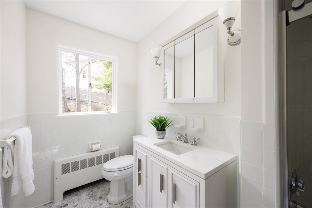 535 Clinton Road Brookline, MA 02467 - Photo 8 of 12 a bathroom with a toilet a sink and a window