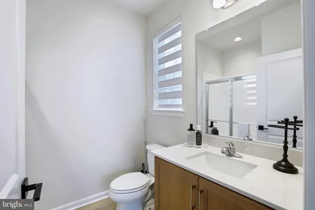 a bathroom with a sink a toilet and a mirror