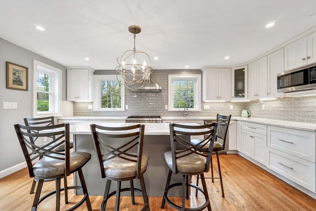 87 Payson Road Brookline, MA 02467 - Photo 12 of 41 a view of a dining room with furniture a kitchen and wooden floor