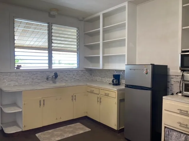 a kitchen with a refrigerator sink and cabinets