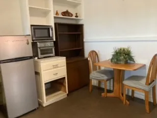 a kitchen with a refrigerator and a chair