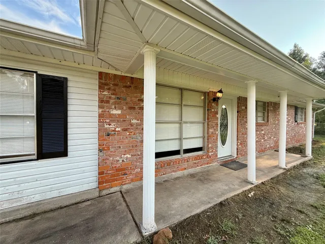 a view of a house with a door and wooden bench