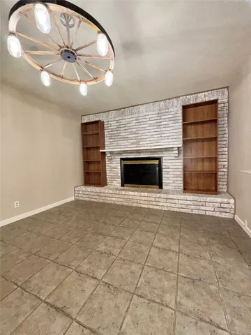 an empty room with fireplace and windows