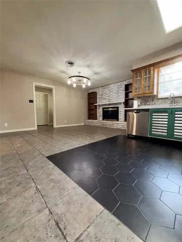 wooden floor in an empty room with a fireplace and window