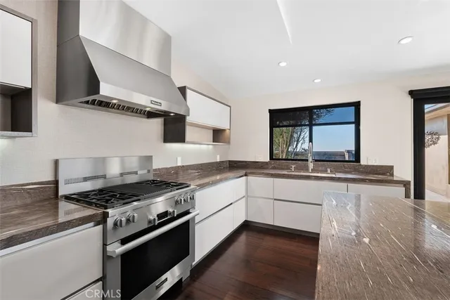 an empty room with wooden floor and a ceiling fan