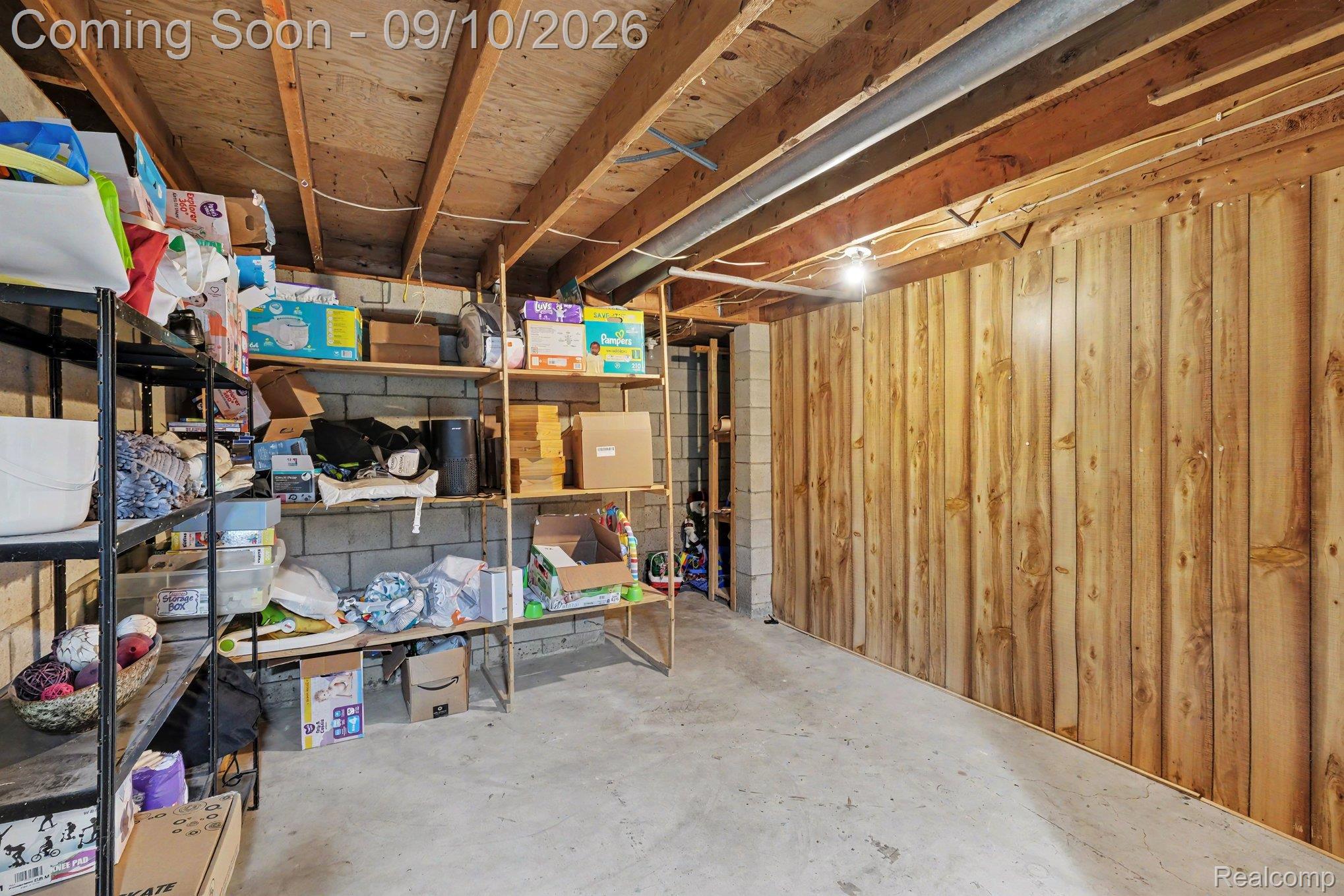 4338 Crosby Road Flint, MI 48506 - Photo 13 of 16 Concrete flooring, wood plank wall paneling, exposed wood ceiling joists, and block wall construction