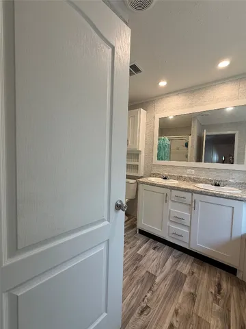 a bathroom with a double vanity sink mirror and bathtub