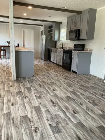 a living room with stainless steel appliances kitchen island granite countertop furniture and a kitchen view