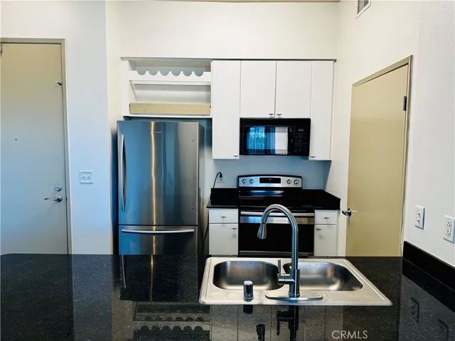 a kitchen with a sink a refrigerator and stove