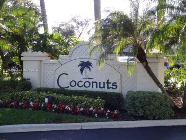 a sign that is sitting in front of flowers