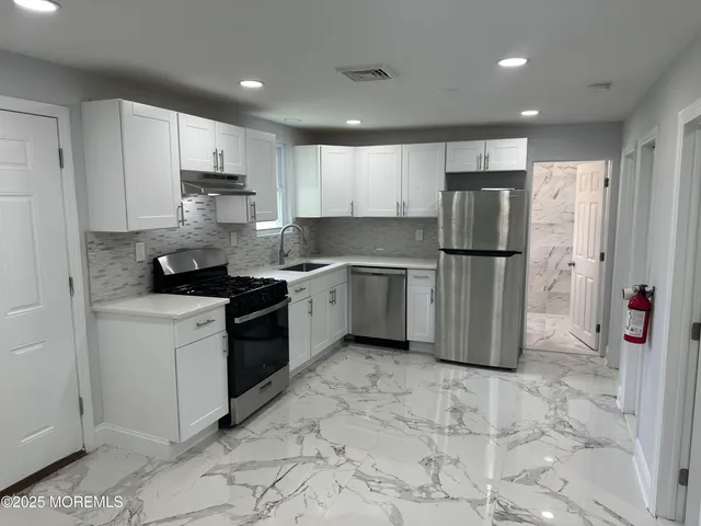 a kitchen with a refrigerator a stove a microwave and cabinets