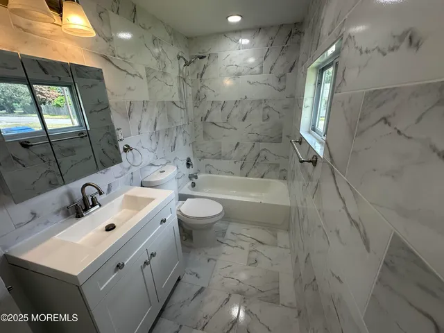 a bathroom with a sink mirror toilet and bathtub