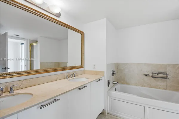 a bathroom with a tub sink and mirror