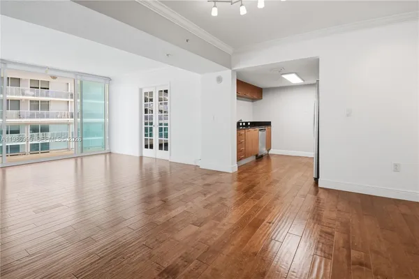 a view of empty room with wooden floor and fan