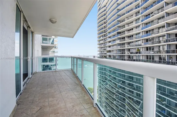 a view of balcony with floor to ceiling windows and brick walls