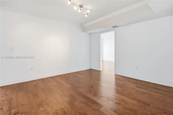 a view of an empty room with wooden floor