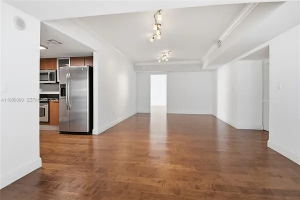 a view of a kitchen with a sink and refrigerator