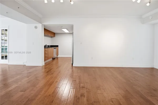 a view of an empty room with wooden floor